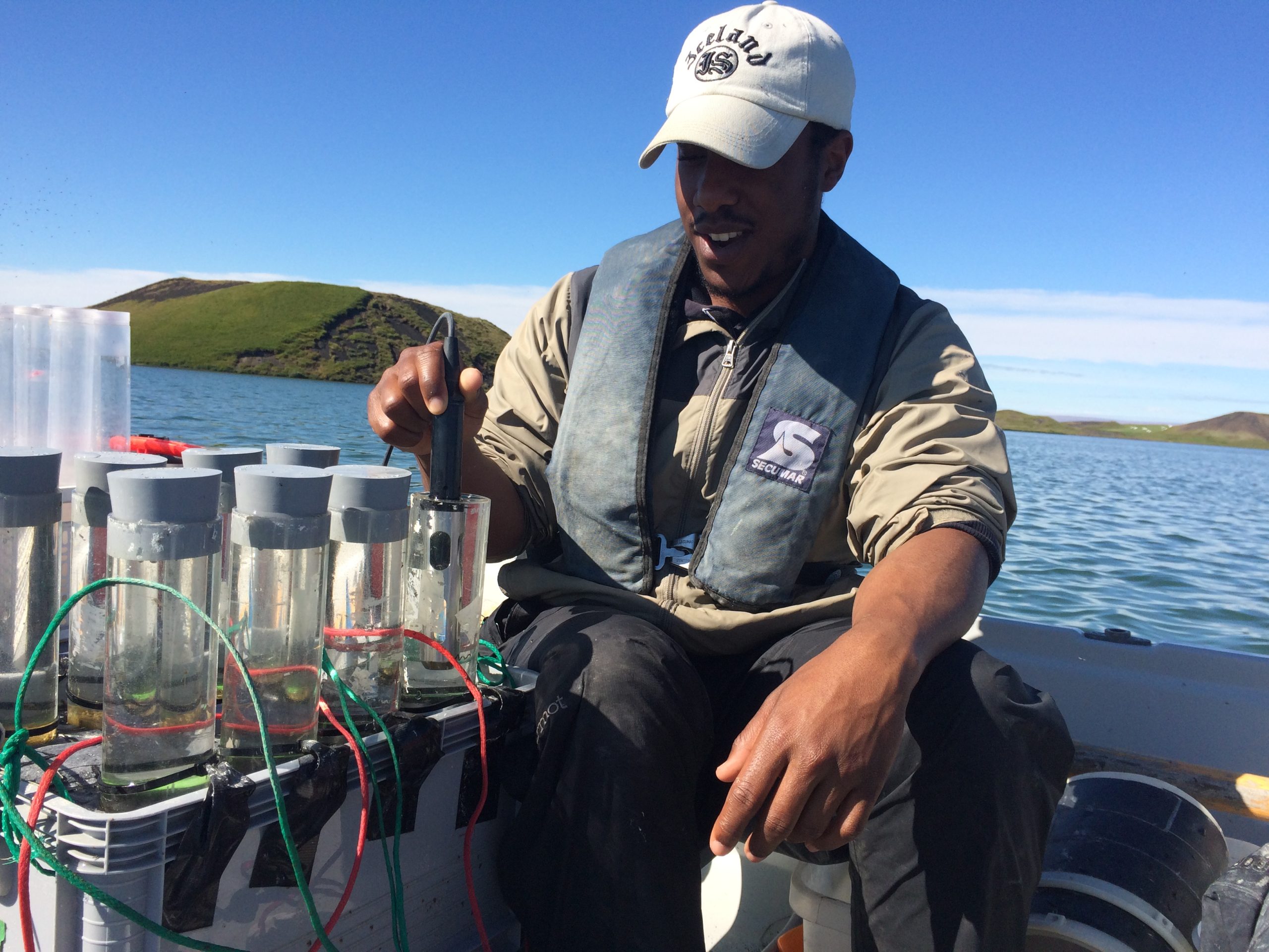 Dr. Matt McCary measures water using field instrument on a boat.