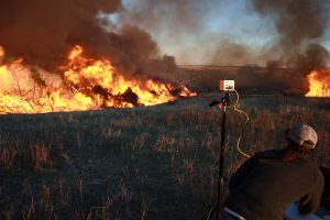 Graduate student Christina Bielski recorded data during a high intensity prescribed fire burning through juniper-invaded grassland on private property. Credit, Dirac Twidwell.