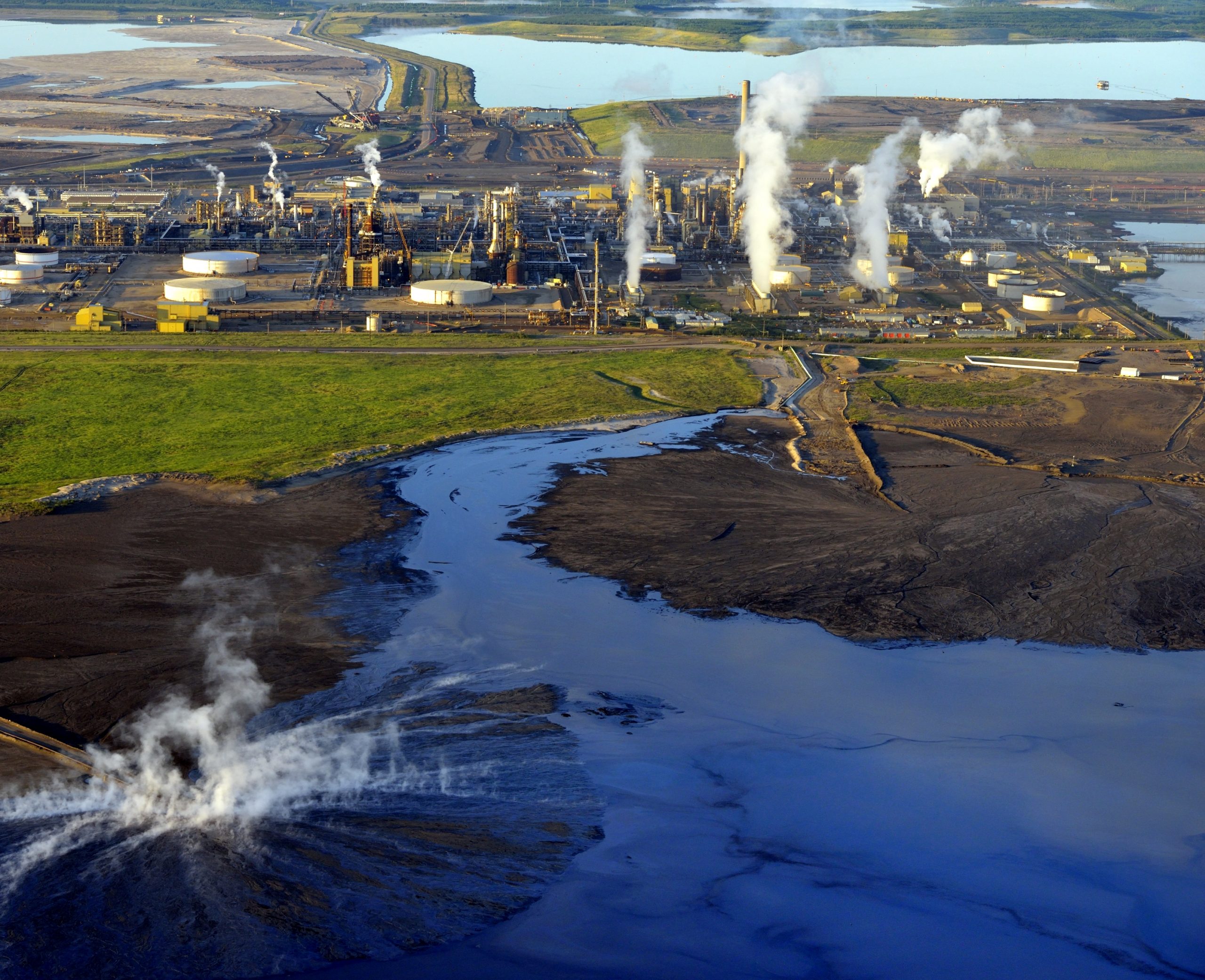 Steam at inflow to tailings pond at Syncrude's Mildred Lake bitumen refinery Oil sands north of Fort McMurray, Alberta