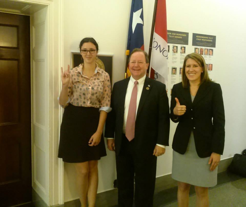 2015 Graduate Student Policy Award winner Emlyn Resetarits (University of Texas-Austin) and fellow graduate student Margot Wood (Texas A&M University) pose with Representative Bill Flores (R-TX) (Center) on Capitol Hill. Each student shows the competitive spirit of their university by giving the “Hook ‘Em Horns” and “Gig ‘Em Aggies” hand signs.