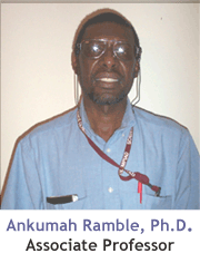 Portrait image of Dr. Ankumah Ramble wearing a blue shirt on a white wall.