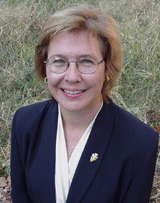 Outdoor portrait of Dr. Ann Bartuska wearing a suit.