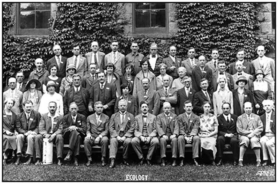 A group of ecologists pose for a group photo.  Four rows deep and thirteen seats across. Circa 1915. Black and White.