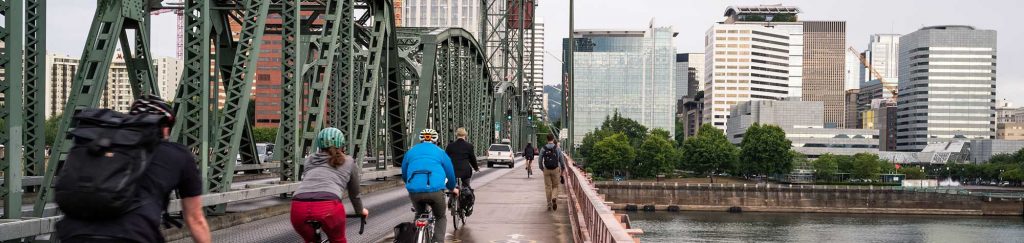 Commuters make their way by bicycle to the city via a bridge.