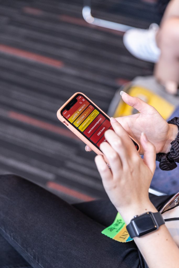 An attendee explores the meeting app on their phone.