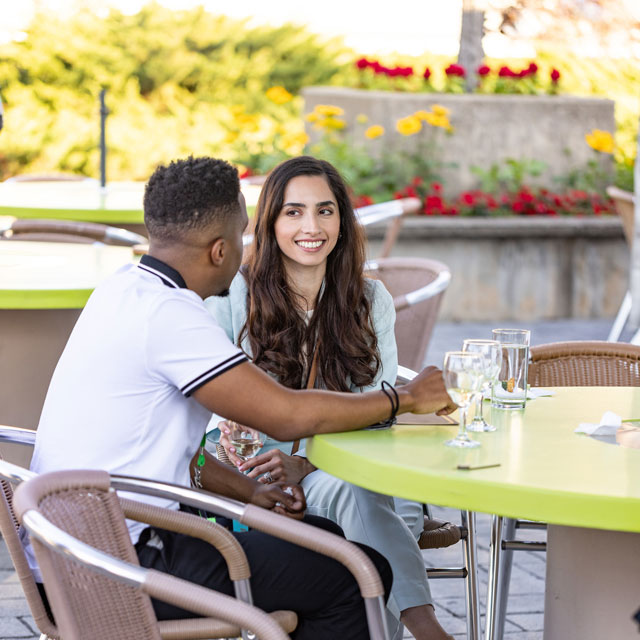 Two people discuss at a table with drinks.