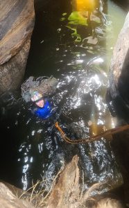 Canyoneer swimming in pothole