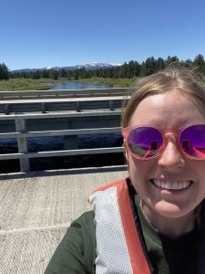 Selfie of Ally standing on a bridge over the Madison River while collecting water samples outside of Yellowstone National Park 
